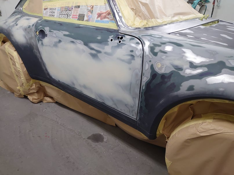 a porsche car is being primed painted in a spray booth, car body repair garage in cardiff